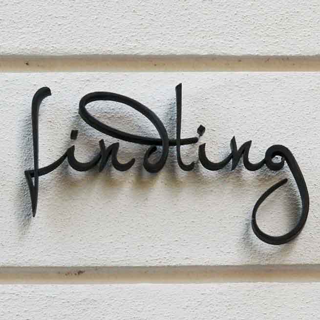 Geschwungener Schriftzug aus Bronze