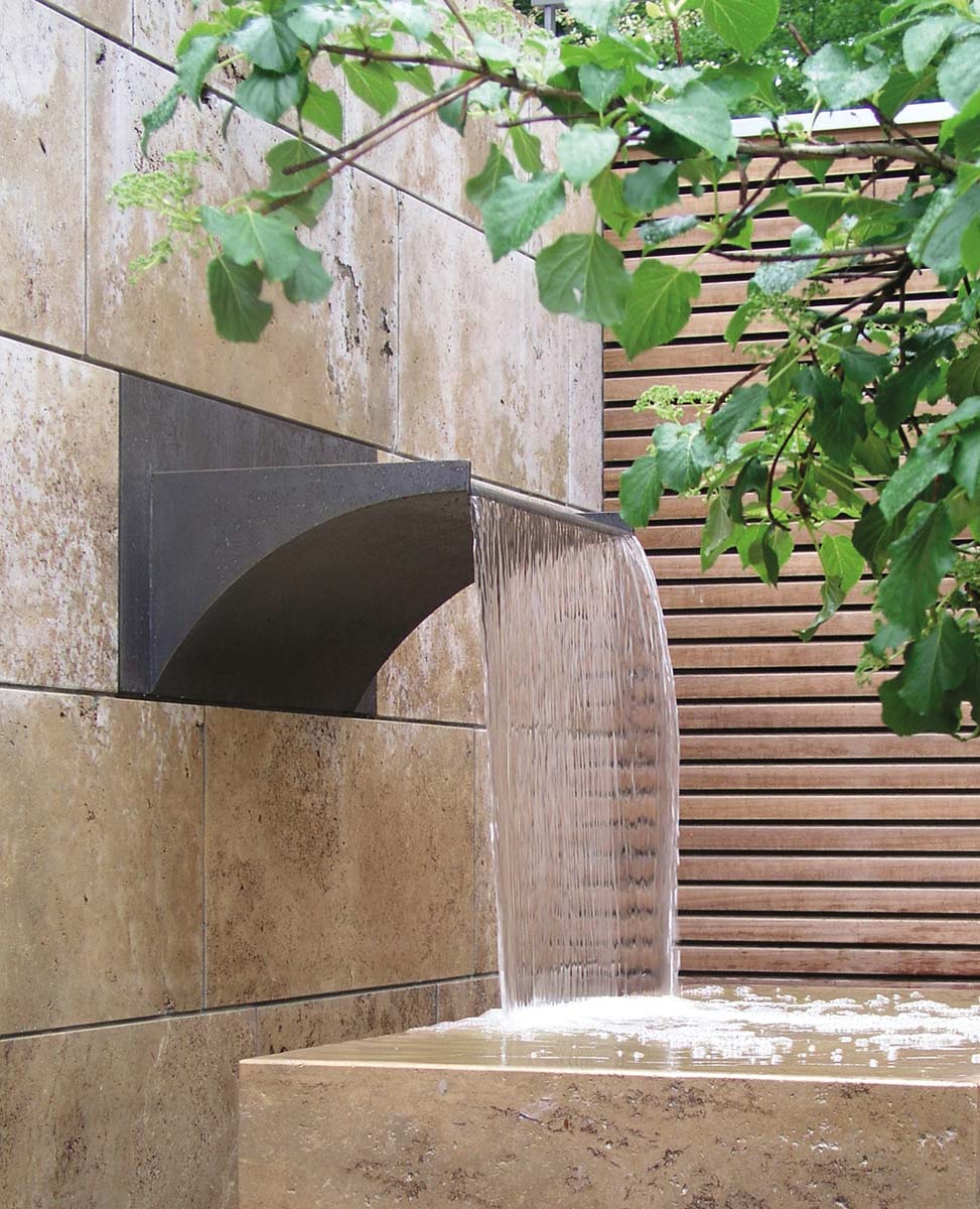Wasserschütte aus Bronze in Natursteinwand eingelassen