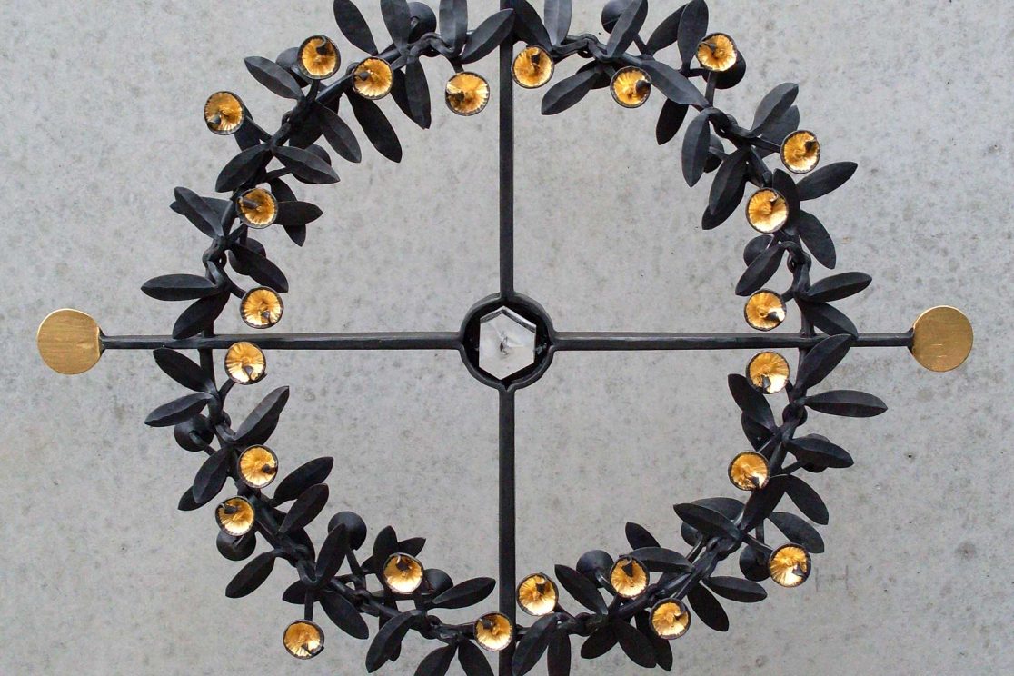 Detail eines zeitgenössischen Grabkreuzes mit stilisierten Blüten und Blättern
