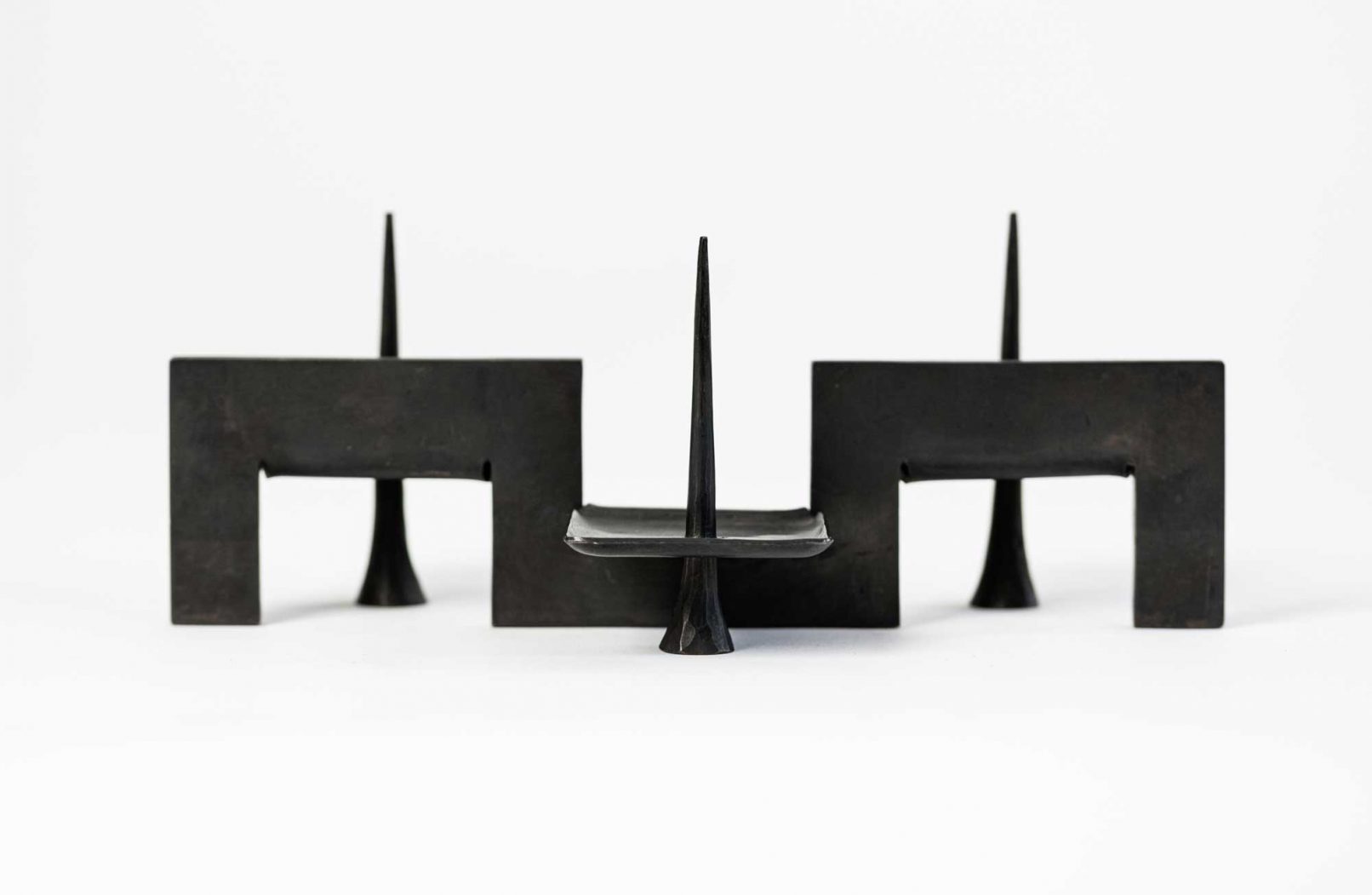 Seitenansicht geometrischer dreiarmiger Kerzenleuchter aus Bronze