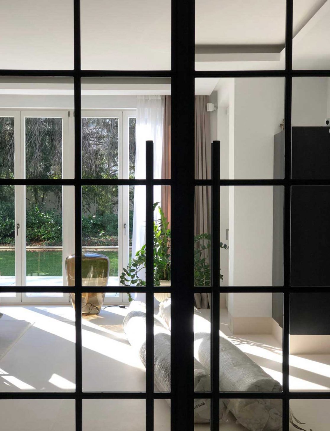 Blick durch die verglaste Stahltüre in den Wohnraum