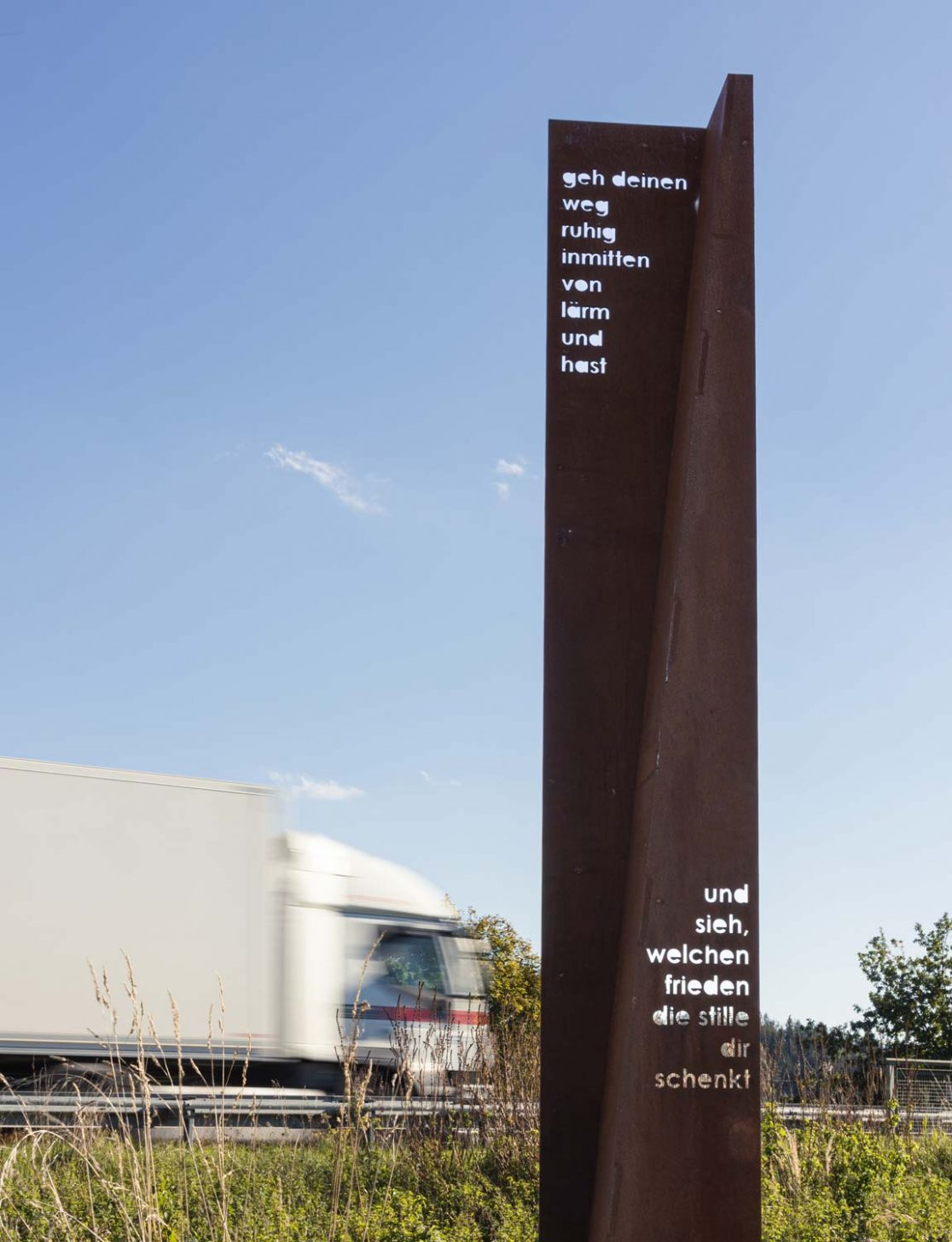 Skulpturale Stele neben Straße auf Meditationsweg in der Gemeinde Ebersberg