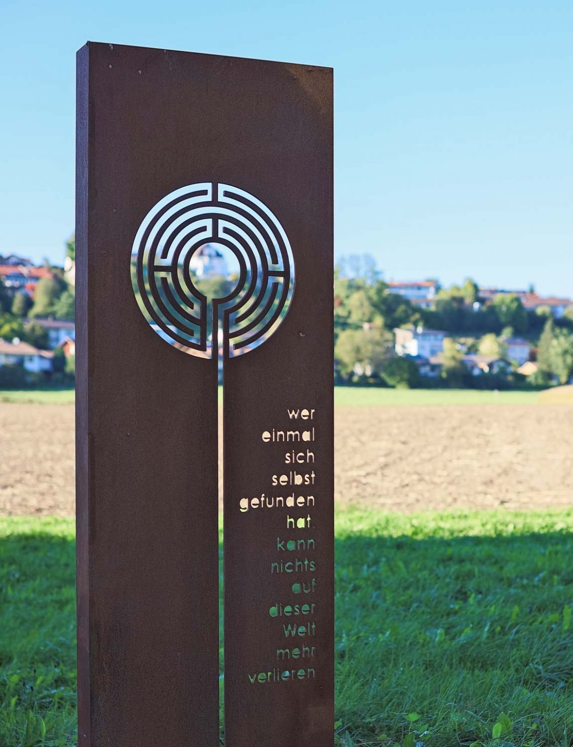 Skulpturale Stele aus Stahl mit Labyrinth-Motiv